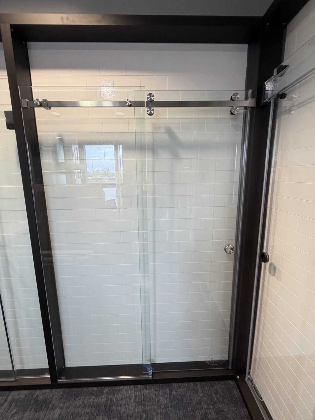 Black-framed gridded glass shower door