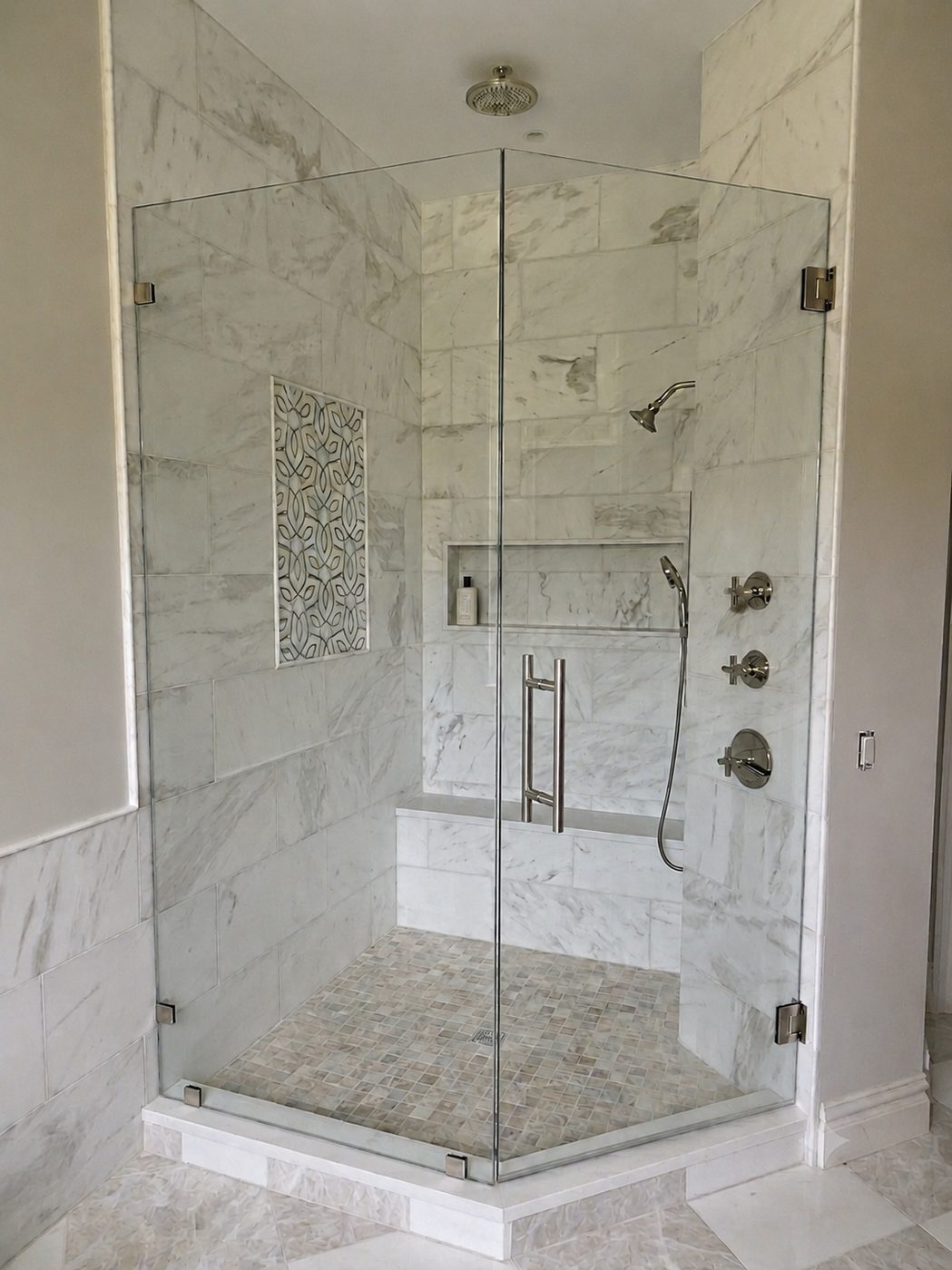 Neo-angle frameless shower in marble with chrome hardware and a bench